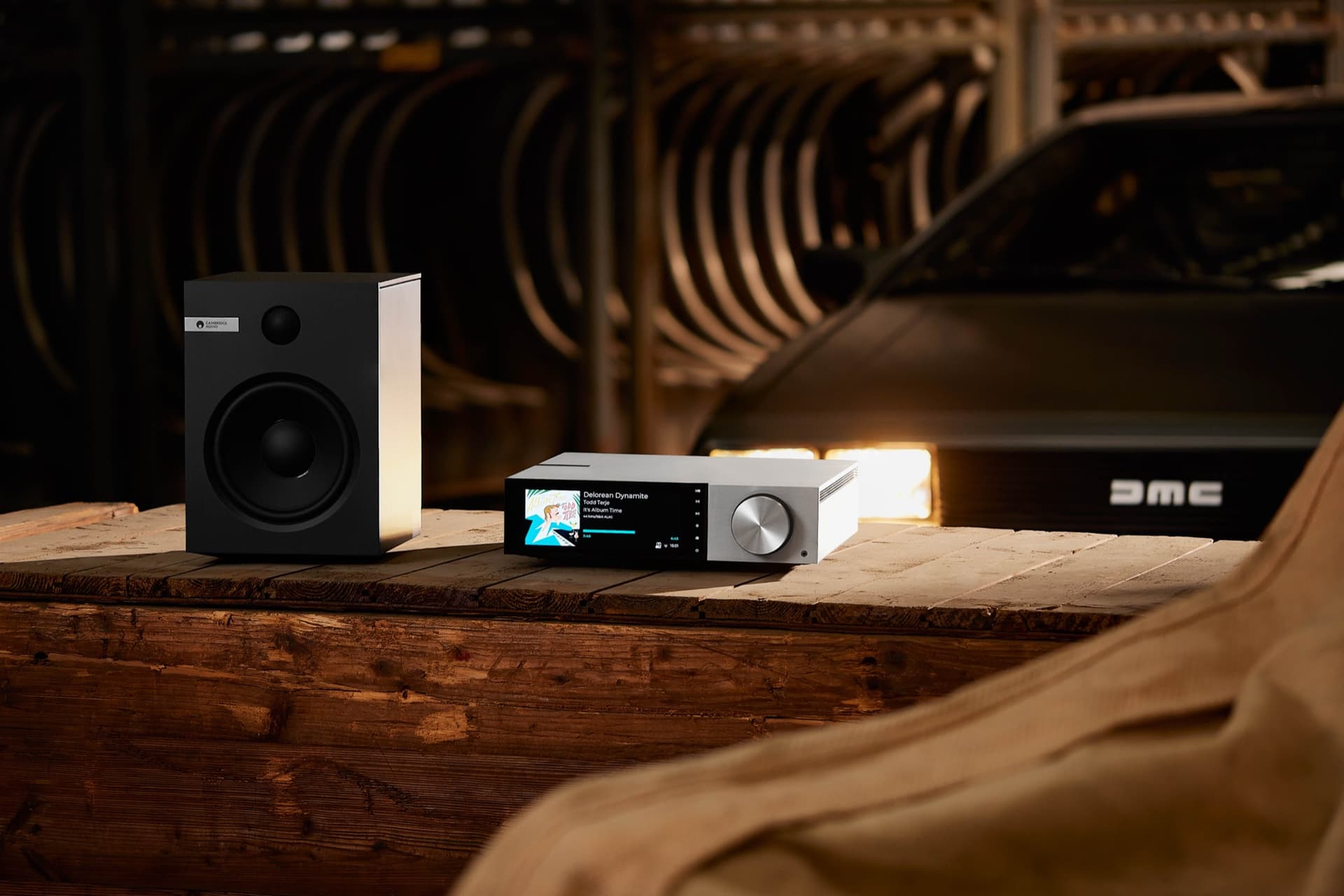 Cambridge Audio speaker and receiver on a wooden table beside the DeLorean
